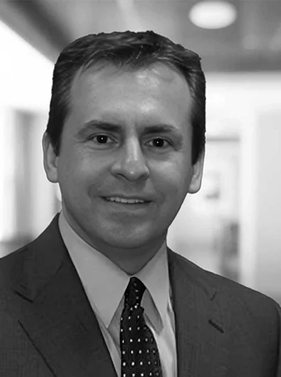 Dr. Gonzalez smiling with a suit and tie
